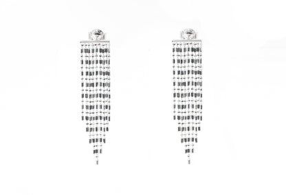 Pair of silver earrings with black and white pattern on a white background