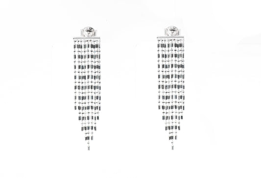 Pair of silver earrings with black and white pattern on a white background