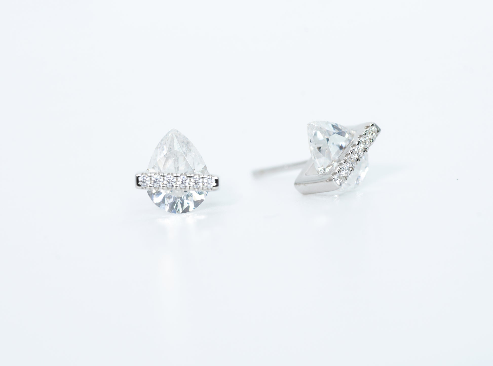 Pair of diamond stud earrings on a light gray background