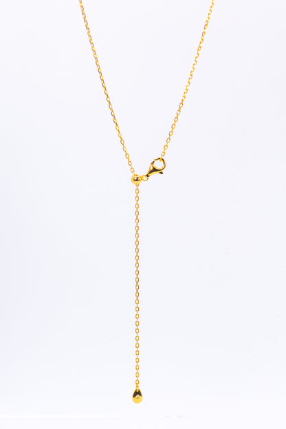 Gold necklace with a small pendant on a white background