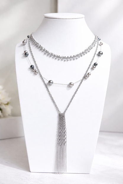 Silver necklace with beads and tassel on a white mannequin bust.