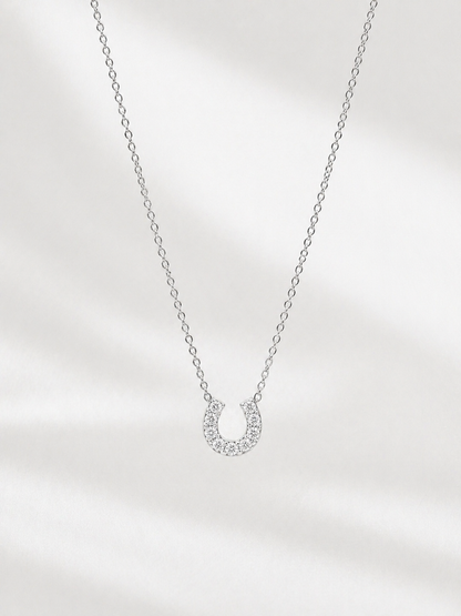 Silver necklace with a small pendant on a light gray background