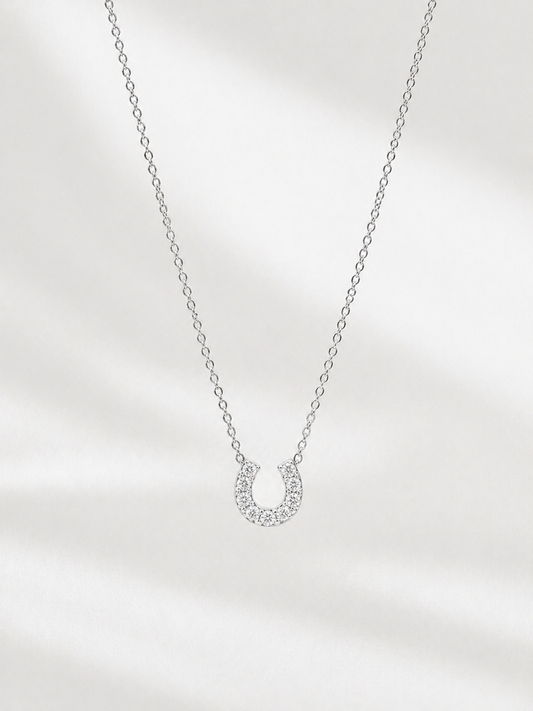 Silver necklace with a small pendant on a light gray background