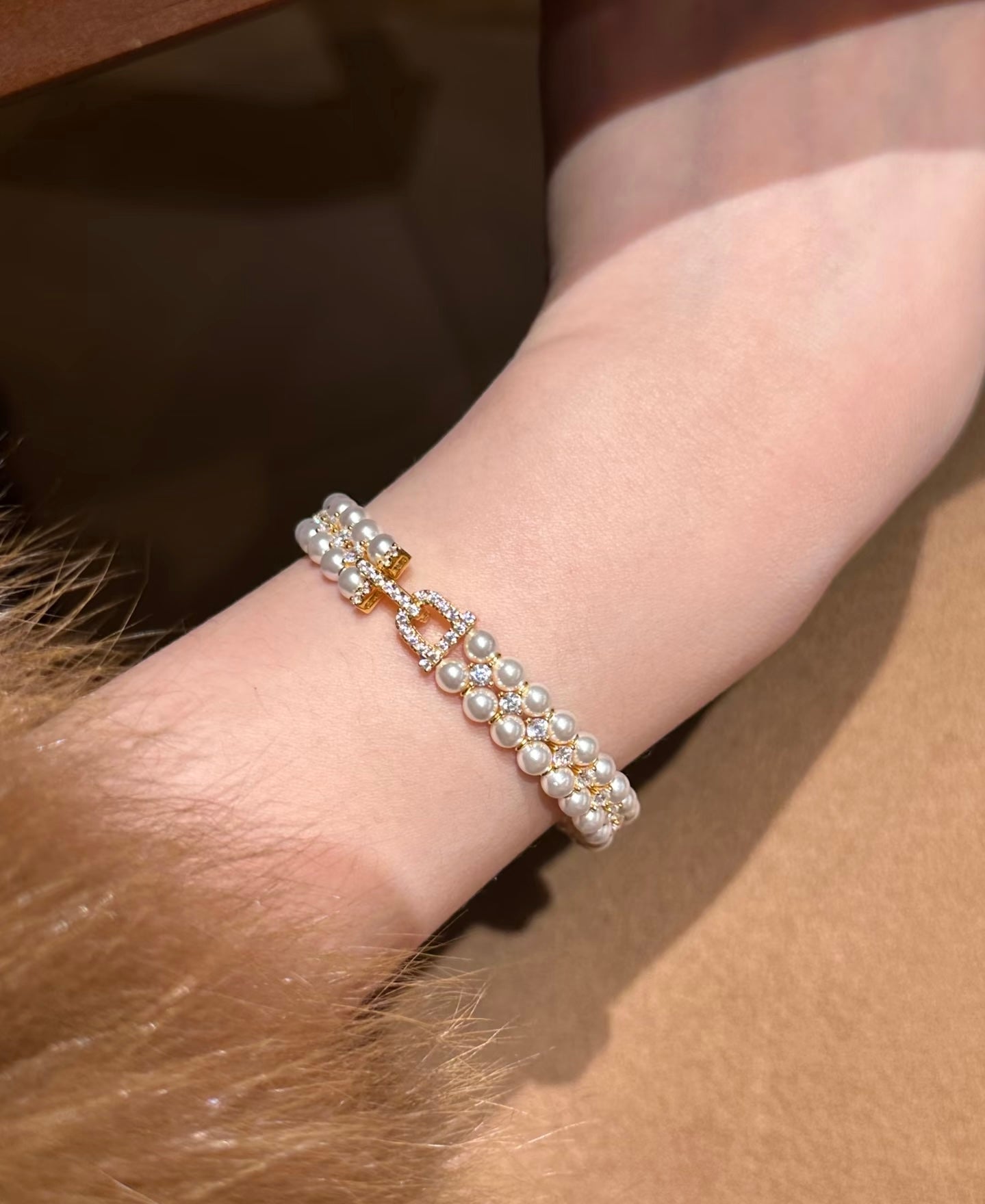 Pearl bracelet on a wrist with a neutral background
