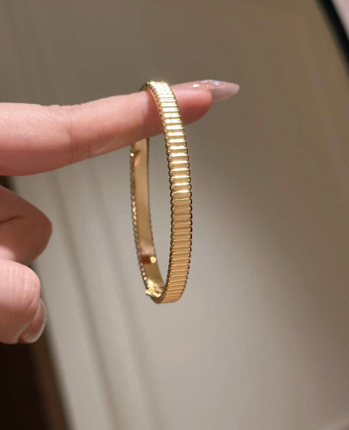 Lunelle Atelier high-polish ribbed bangle bracelet with sleek, rounded design and textured ribbing on shiny silver surface.