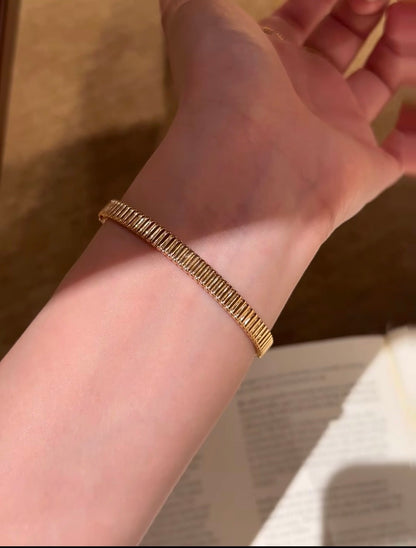 Lunelle Atelier high-polish ribbed bangle bracelet with textured, shiny surface, displayed on a neutral background