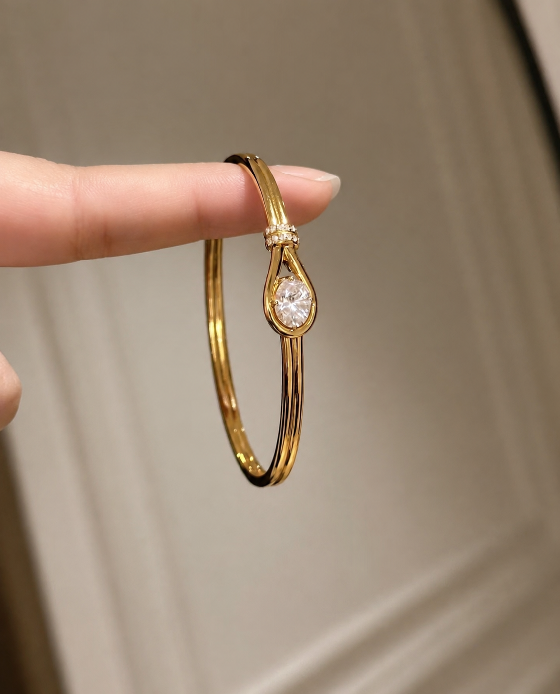Lunelle Atelier teardrop solitaire open bangle bracelet with a sleek gold design and a prominent teardrop-shaped gemstone.