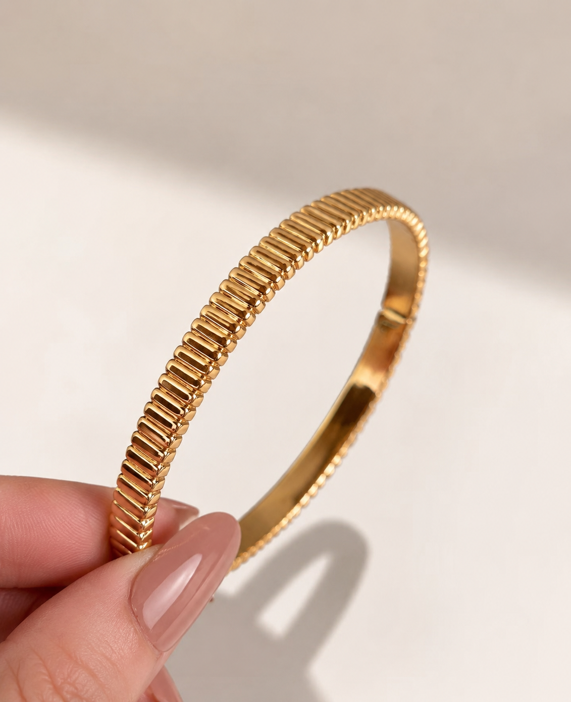 Lunelle Atelier high-polish ribbed bangle bracelet with textured design, showcasing a sleek, shiny finish on a white background.