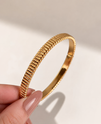 Lunelle Atelier high-polish ribbed bangle bracelet with textured design, showcasing a sleek, shiny finish on a white background.