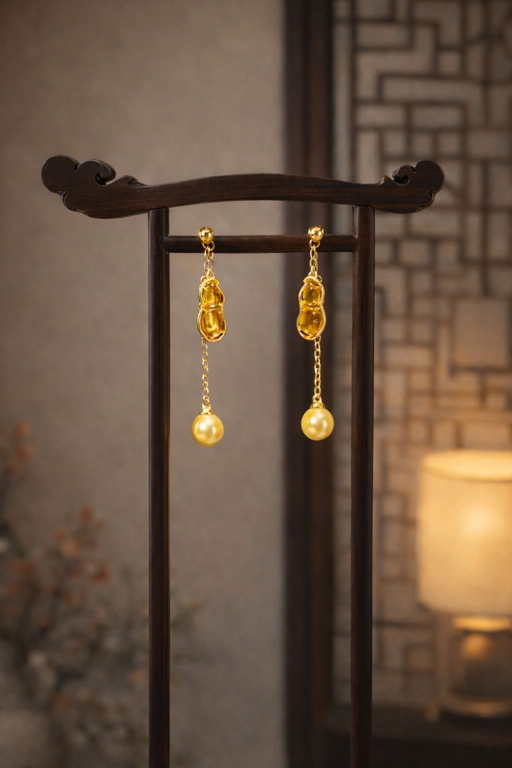 Gold earrings on a dark stand with a blurred background
