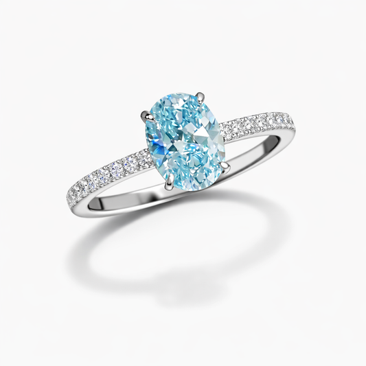Ring with a blue gemstone and diamond-studded band on a white background