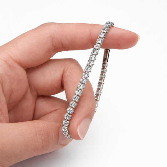 Hand holding a diamond bracelet on a white background
