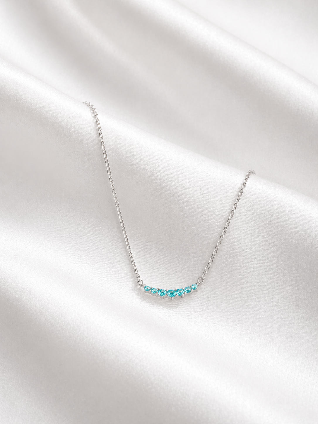 Necklace with blue gemstones on a white fabric background