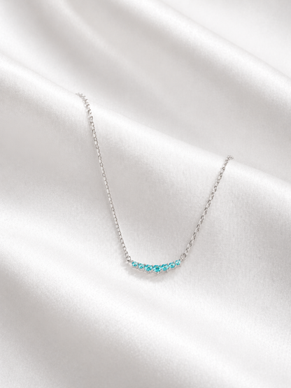 Necklace with blue gemstones on a white fabric background