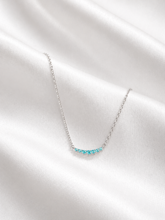 Necklace with blue gemstones on a white fabric background
