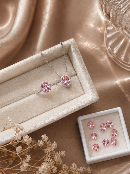 Pink gemstone jewelry set on a beige surface with a soft focus background