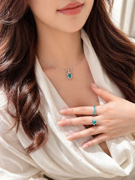 Close-up of a woman wearing a necklace and ring with a blue gemstone.