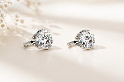 Pair of diamond earrings on a soft beige background