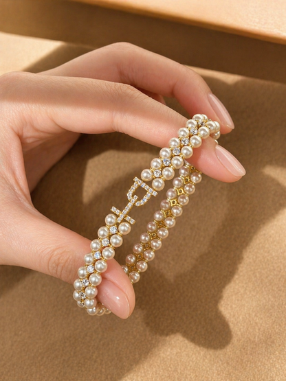 Hand holding a pearl headband against a beige background