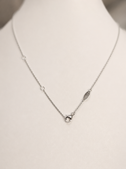 Silver necklace on a mannequin with a neutral background