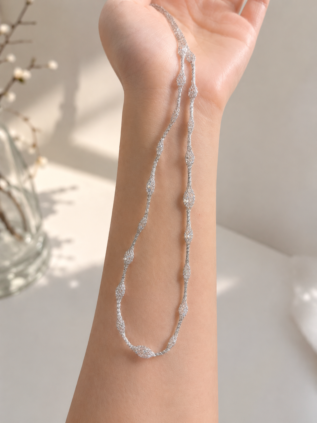 Lunelle Atelier Veil of Light woven necklace featuring delicate, intricate design with light-colored threads and subtle metallic accents.