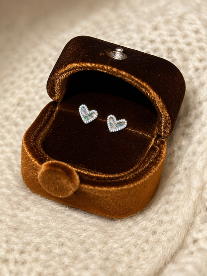Lunelle Atelier laser heart stud earrings with shiny metallic finish, featuring small heart-shaped designs on each earring.
