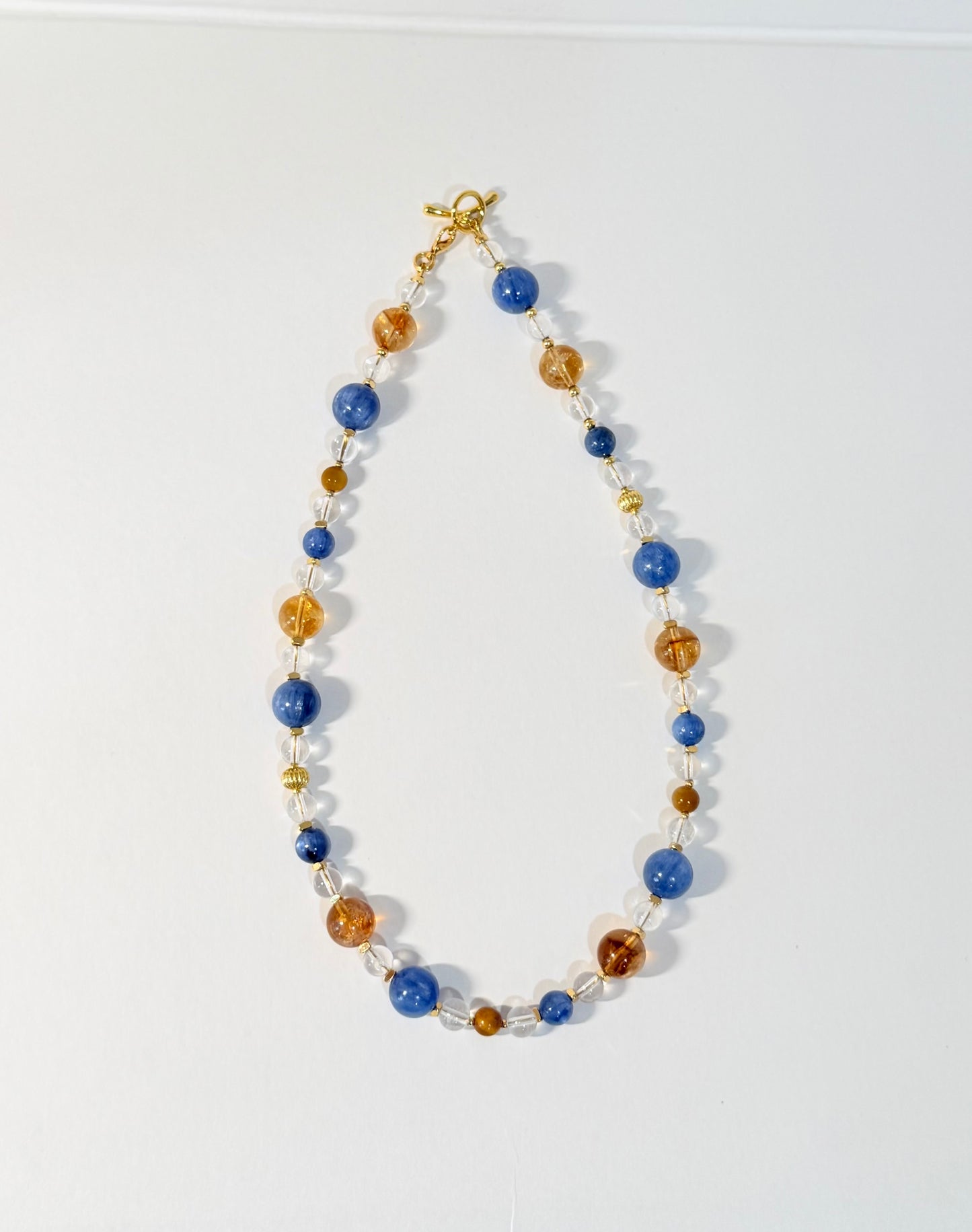 Necklace with blue and gold beads on a white background