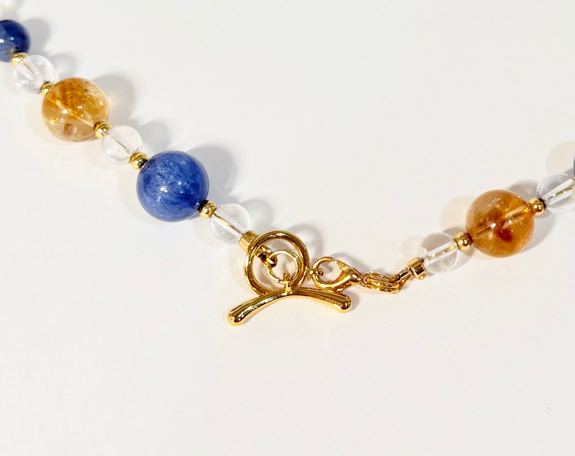 Bracelet with multicolored beads and a gold clasp on a white background