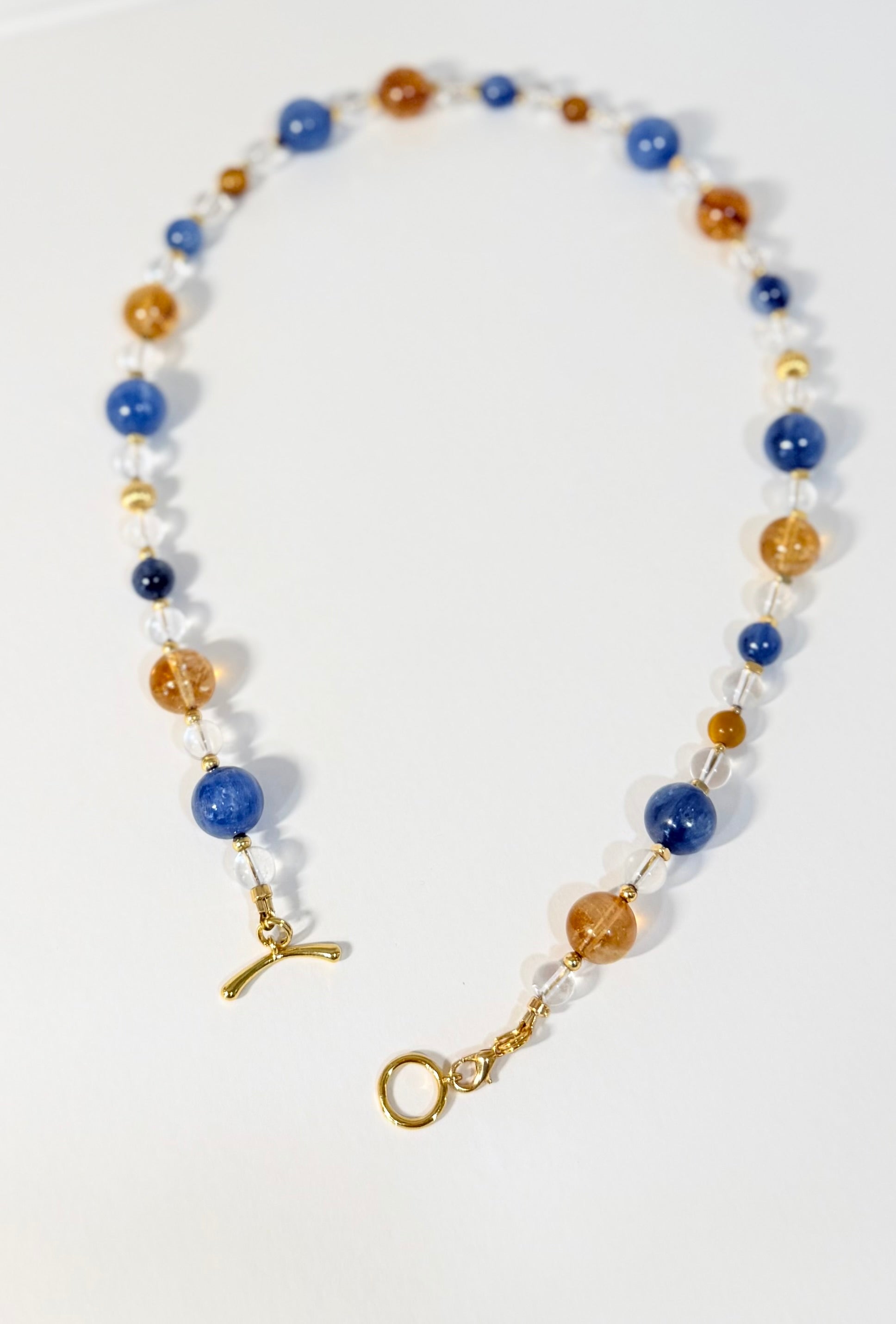 Necklace with blue, gold, and white beads on a white background