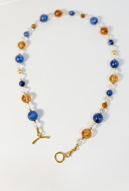 Necklace with blue, gold, and white beads on a white background