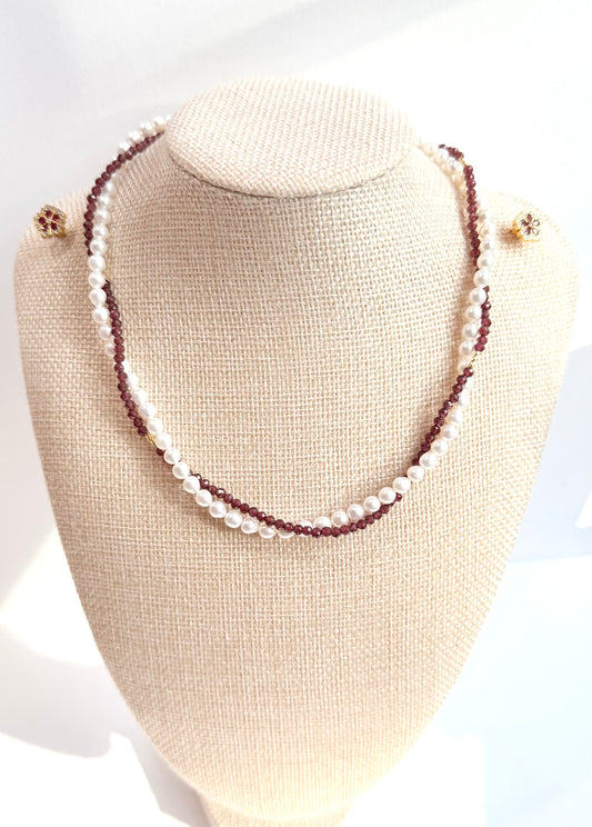 Necklace with white pearls and red beads on a beige bust