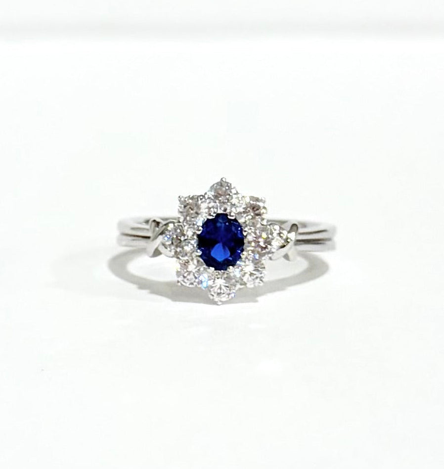 Silver ring with a blue gemstone on a white background