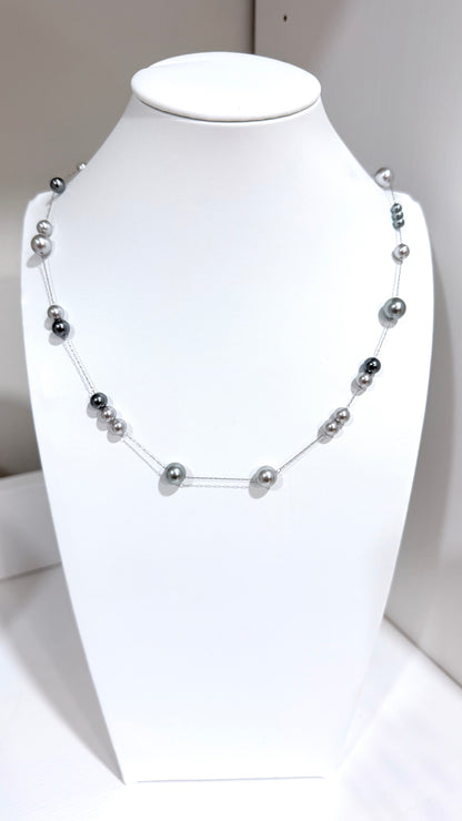 Pearl necklace on a mannequin bust against a white background