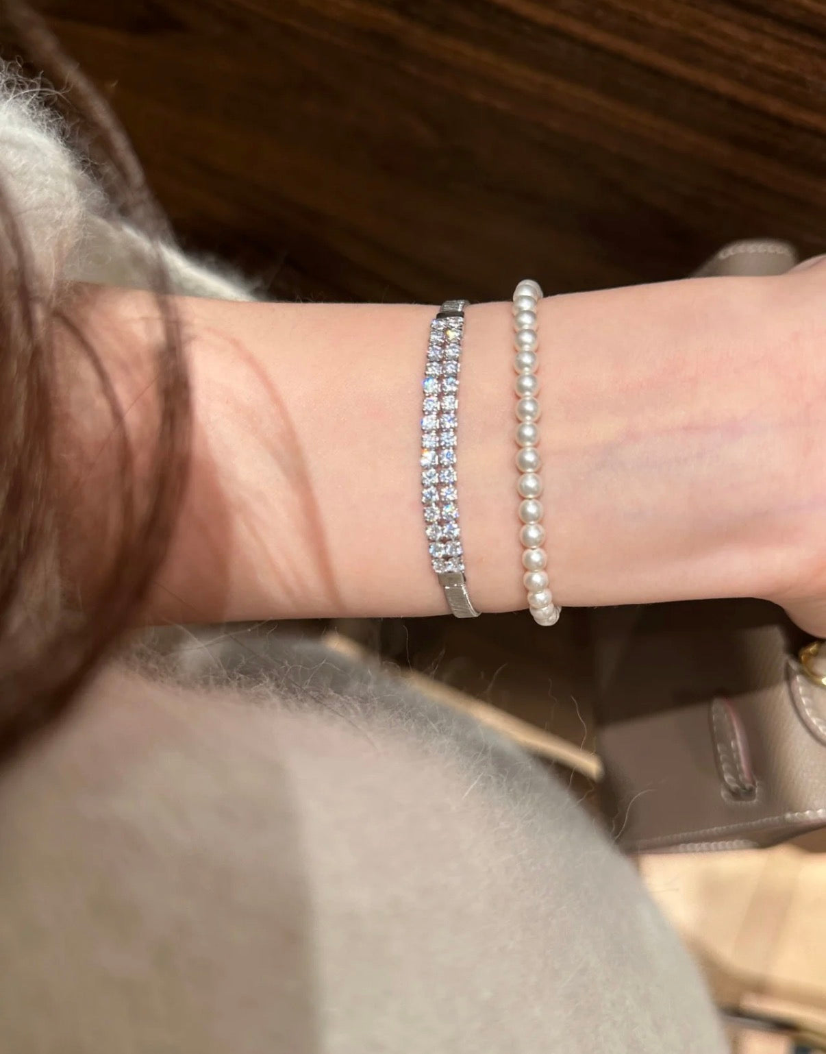 Close-up of a wrist wearing two bracelets with a blurred background