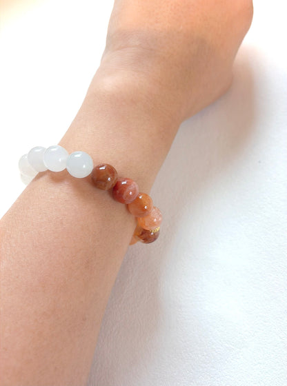 Close-up of a wrist wearing a bracelet with multicolored beads on a white background