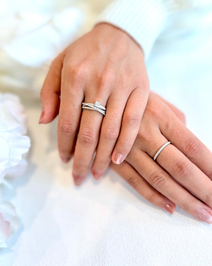 Close-up of two hands wearing silver rings on a blurred background