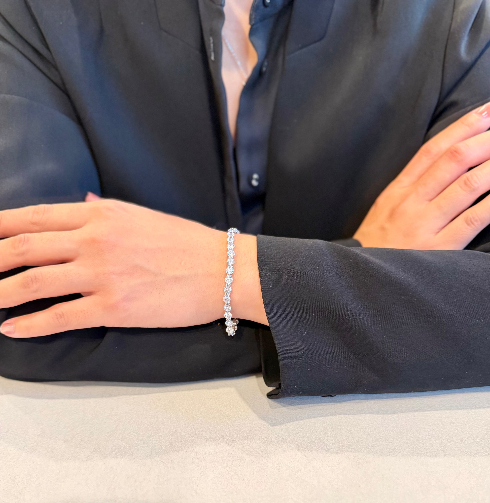 Person wearing a silver bracelet with a plain background