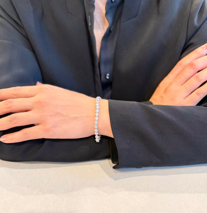 Person wearing a silver bracelet with a plain background