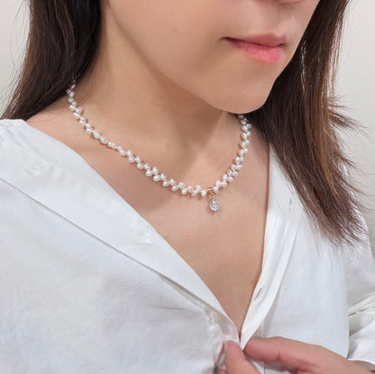 Woman wearing a pearl necklace with a white blouse