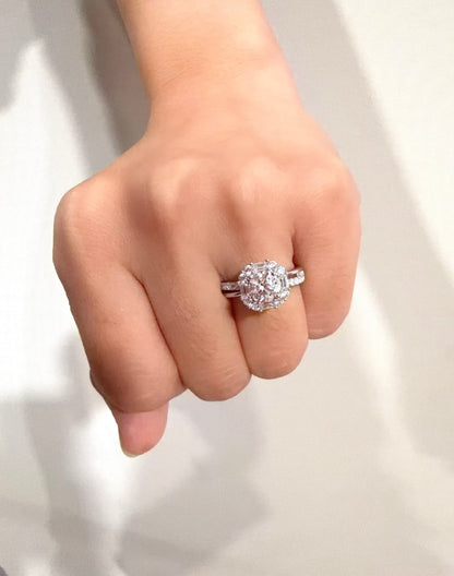 Hand wearing a silver ring with a diamond on a white background