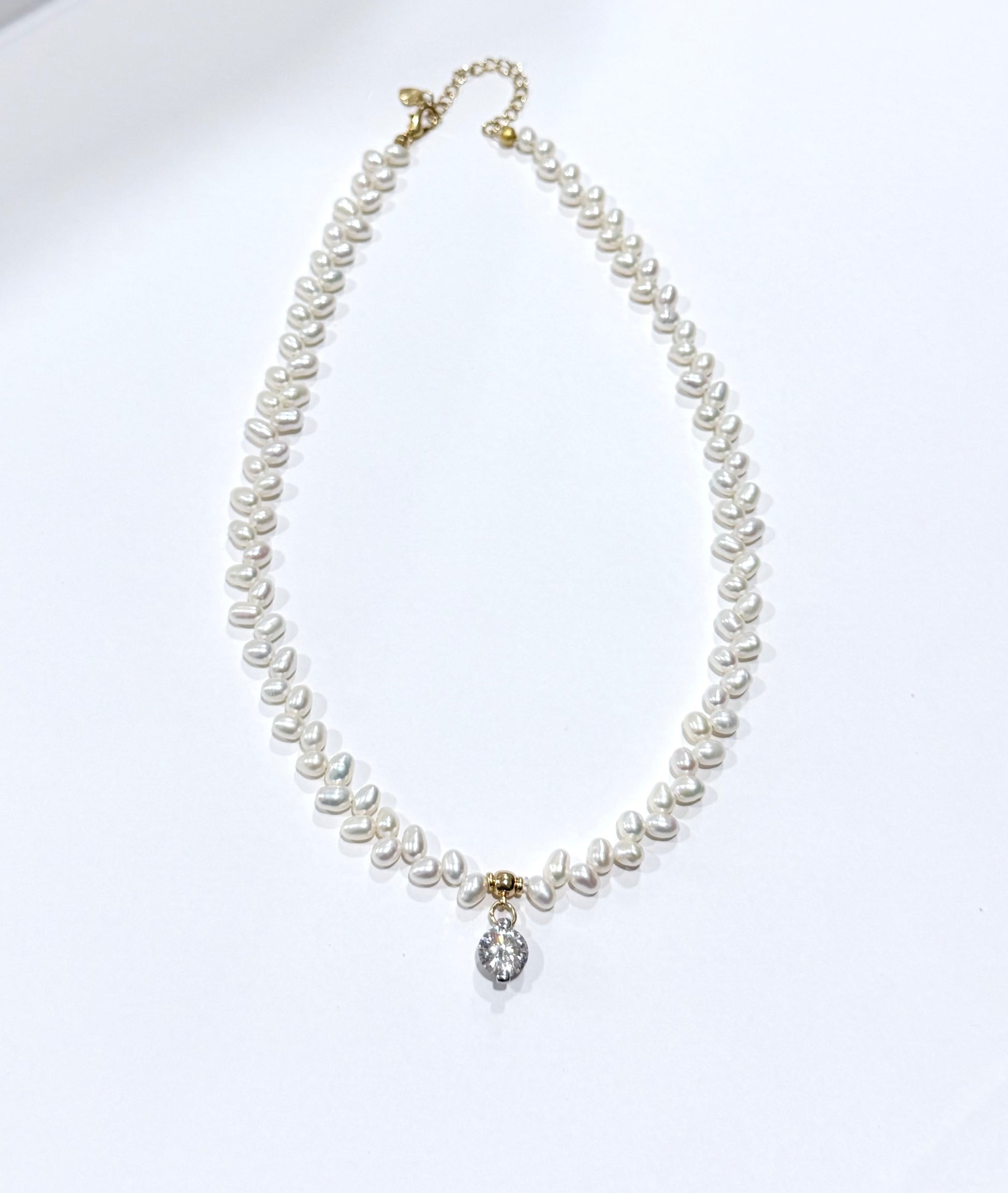 Pearl necklace with a silver clasp on a white background