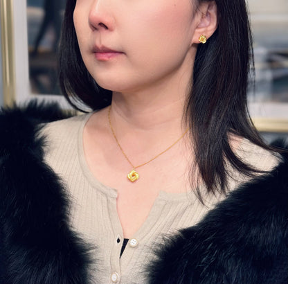 Woman wearing gold color necklace and earrings with a blurred background
