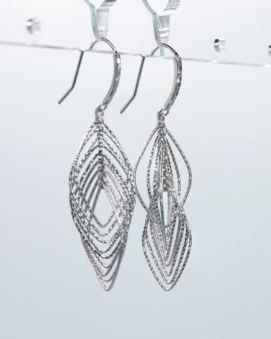 Silver earrings with intricate design on a light gray background