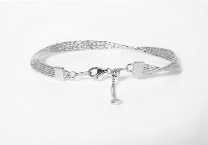 Silver bracelet with a horse bit charm on a white background