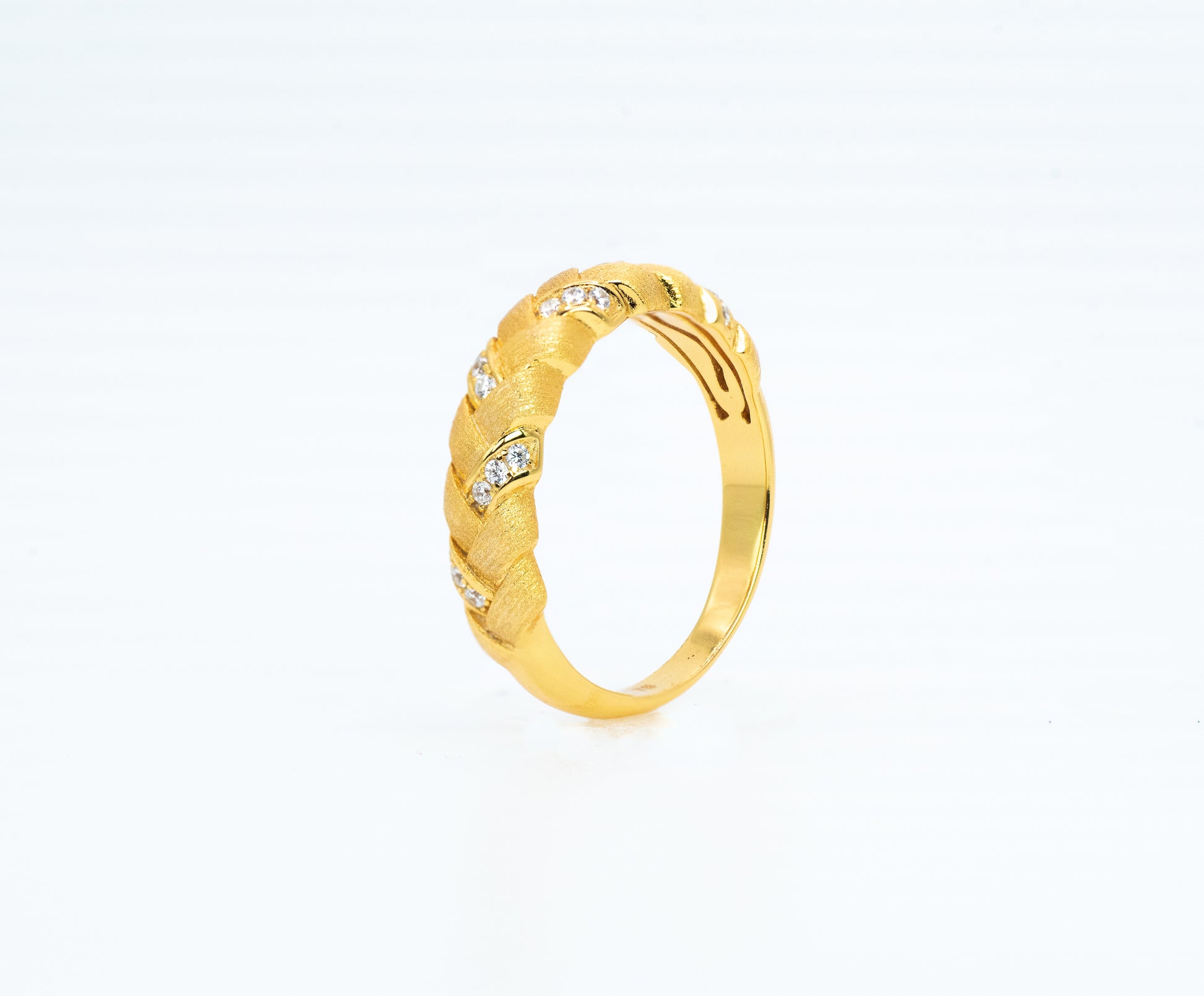 Gold ring with diamond accents on a white background