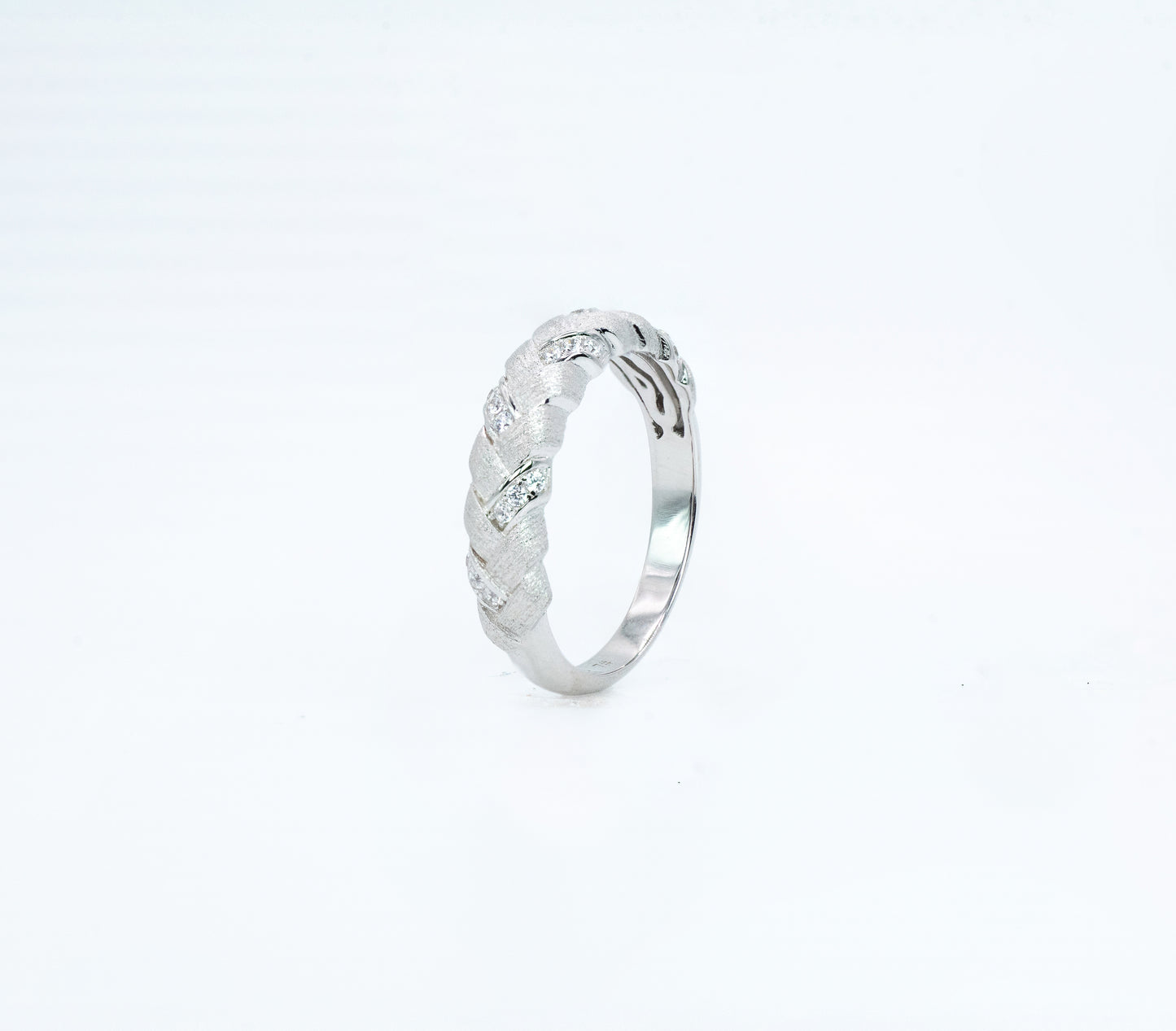 Silver ring with intricate design on a white background