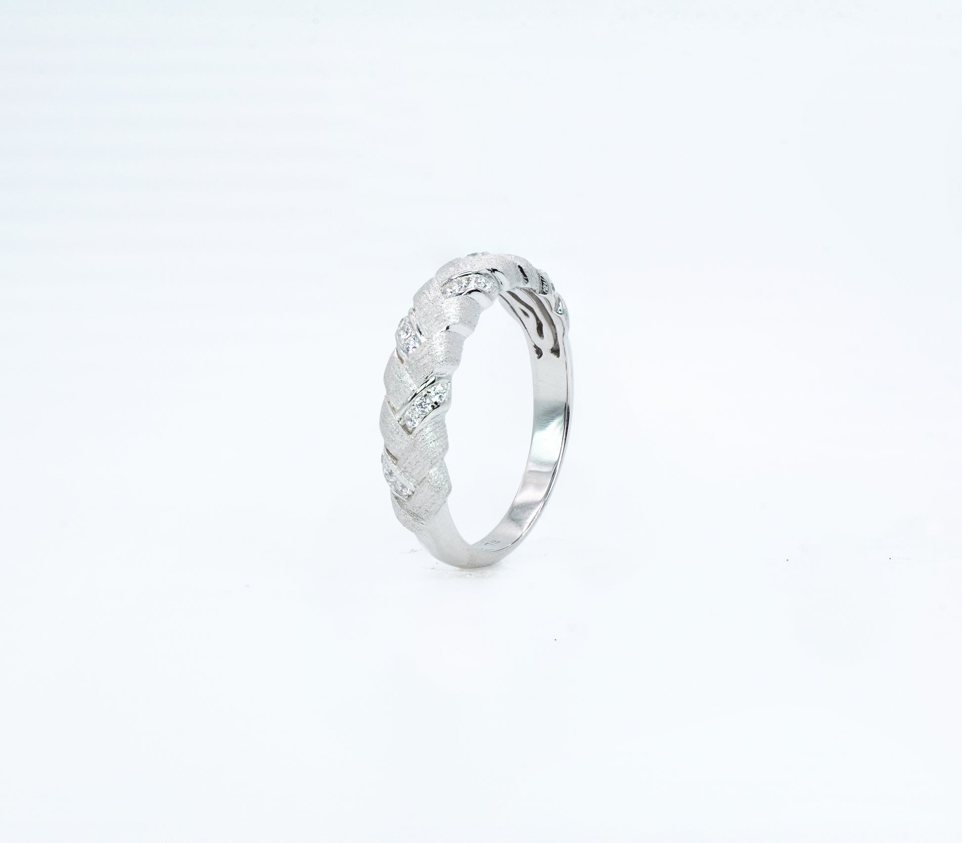 Silver ring with intricate design on a white background