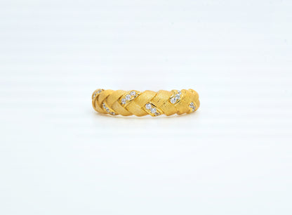 Gold braided ring with embedded diamonds on a light gray background